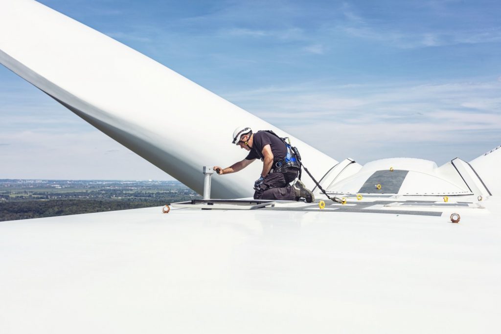 Ein Mitarbeiter der energy consult steht auf einer Windenergieanlage